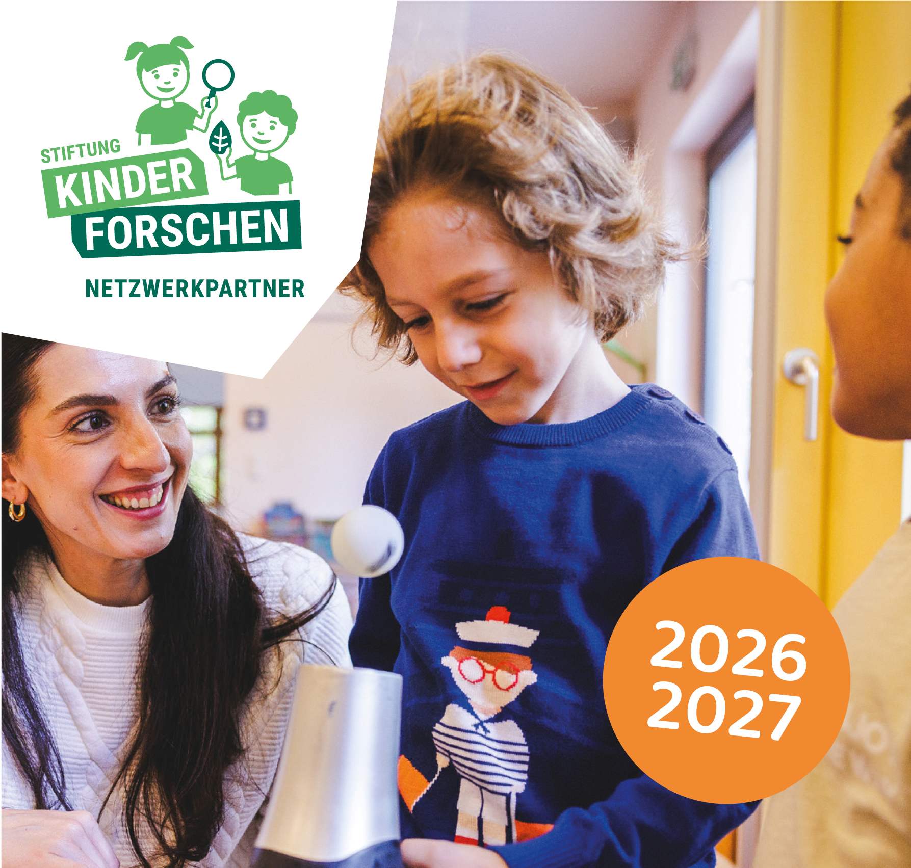 Titelbild der Fortbildungsbroschüre des Netzwerk Kinder forschen. Eine Gruppe von Kindern sitzt mit einem Lehrer an einem Tisch. Bei einem Sprudelvulkan-Experiment mit Natron und Spühlmittel.