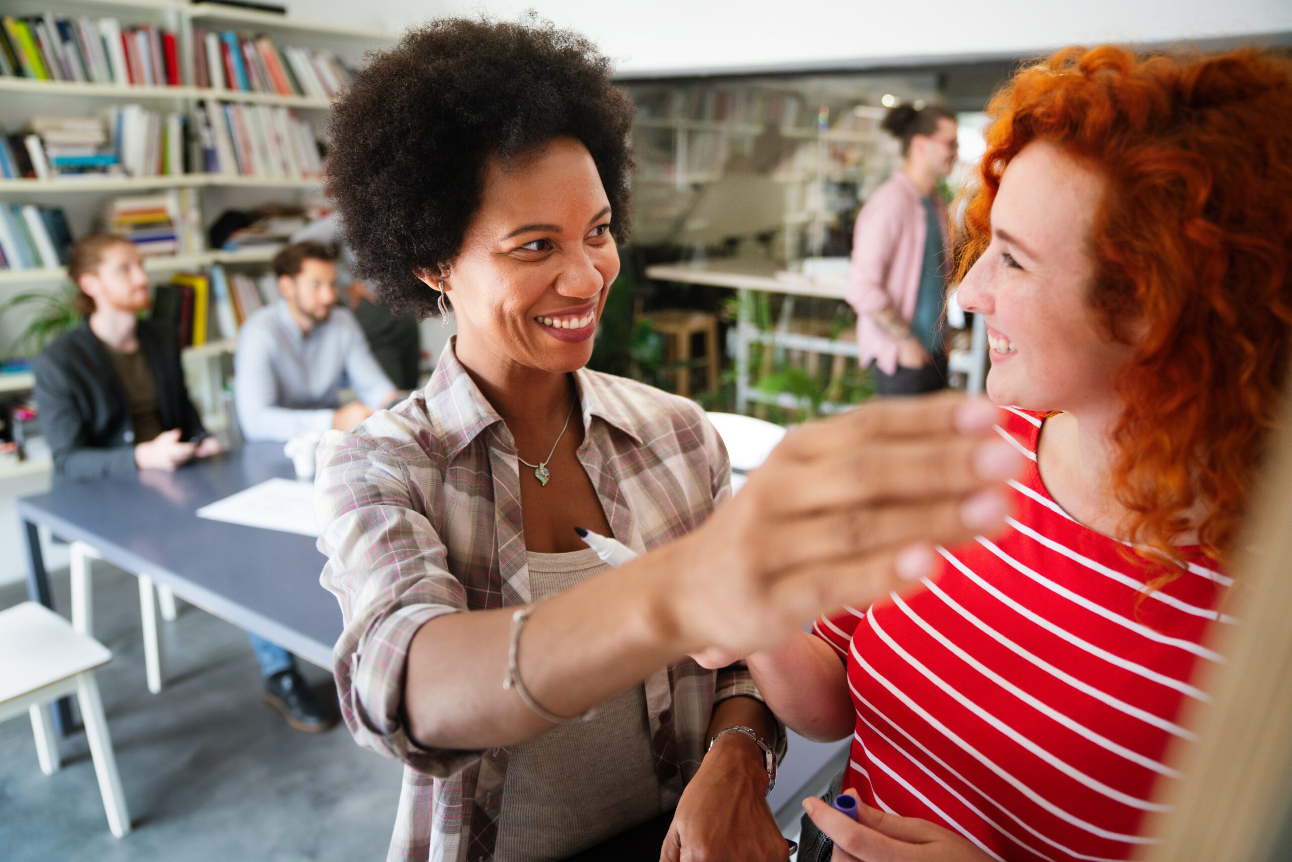 Happy coworker startup people working and having meeting with friendly diverse colleagues in office. Symbolbild zu TOPAS-Seminar: Gemeinsam wachsen - Feedback und Dialog in der eigenen Organisation stärken