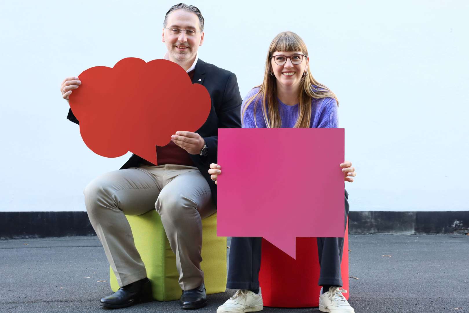 Zwei Mitarbeiter:innen halten Schilder in den Händen. Symbolbild für die Veranstaltung "Arbeitgebermarke im Mittelstand"