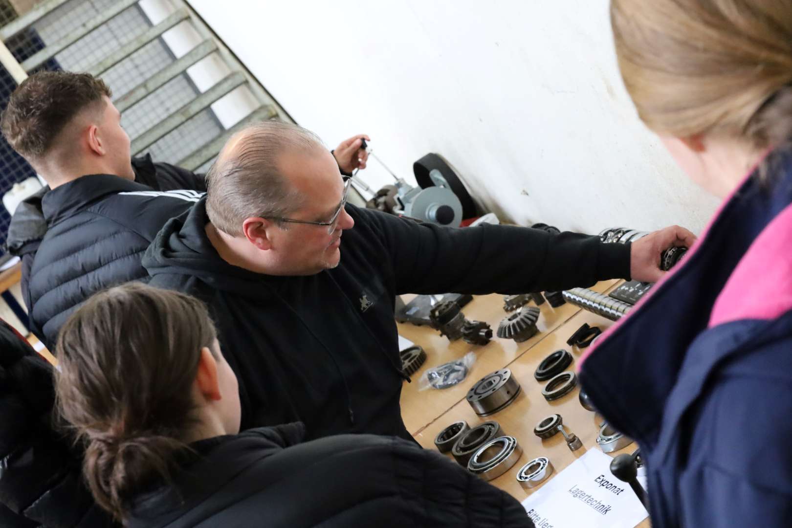 Eine Fachkraft erklärt einer Auszubildenden ein Exponat für Lagertechnik. Symbolbild für die Veranstaltung "Power:Werk:Tage für Azubis."